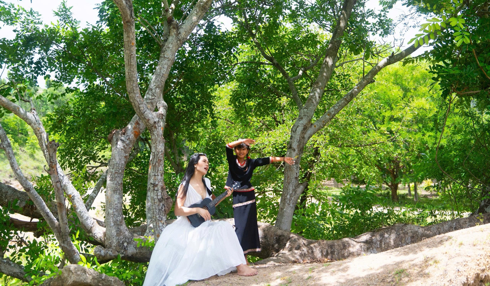 Phúc Anh đàn hát cùng em bé người Gia Rai Phúc Anh và cô bé Gia Rai bên cây đàn